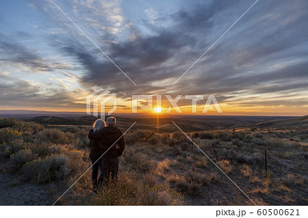 Couple in field at sunset at Boise Foothills in Boise, Idaho, USA 60500621