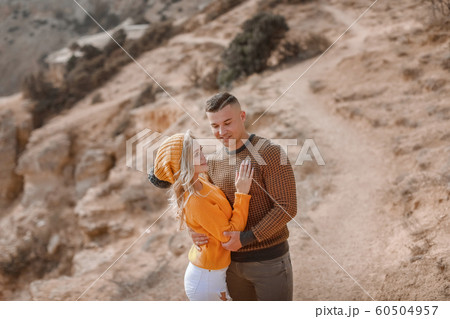 A man and a woman cuddle on a mountain path 60504957