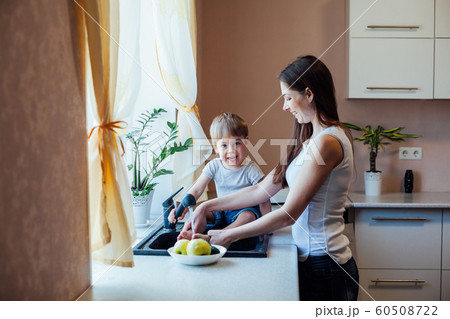 kitchen mom son wash fruits and vegetables kitchen mom son wash fruits and vegetables 60508722