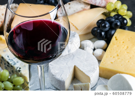 glass of red wine on the background of assorted cheeses glass of red wine on the background of assorted cheeses 60508779