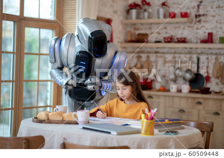 Robot teacher looking attentively how the girl writing Robot teacher looking attentively how the girl writing 60509448