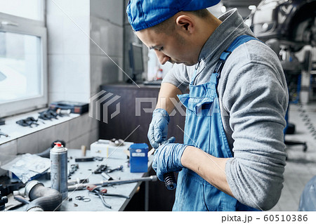 Repairman in car service working with small details on table 60510386