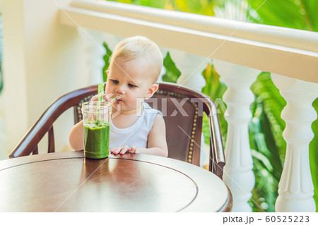 Child boy drinking healthy green vegetable smoothie - healthy eating, vegan, vegetarian, organic food and drink concept Child boy drinking healthy green vegetable smoothie - healthy eating, vegan, vegetarian, organic food and drink concept 60525223