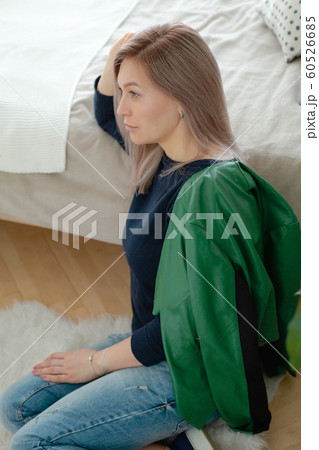 Blonde woman is sitting near the cozy bed Blonde woman is sitting near the cozy bed 60526685