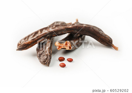 Carob carob fruit and seeds on white background. 60529202
