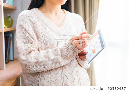 3月 カレンダーに書き込む妊婦 60530487