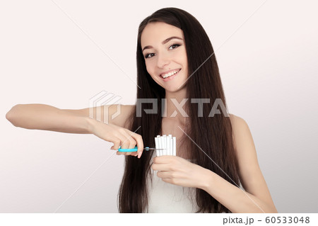 Stop smoking concept. Young woman cut cigarettes with scissors happy smiling. focus on hand, scissors and cigarettes Stop smoking concept. Young woman cut cigarettes with scissors happy smiling. focus on hand, scissors and cigarettes 60533048