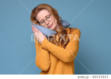 Mature adult woman with neck pillow resting and sleeping comfortable. Mature adult woman with neck pillow resting and sleeping comfortable. 60535923