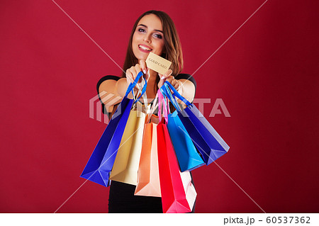 Shopping. Woman holding colored bags on red background in black friday holiday Shopping. Woman holding colored bags on red background in black friday holiday 60537362