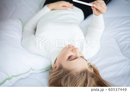 Positive pregnancy test. Young woman feeling depressed and sad after looking at pregnancy test result at home 60537449