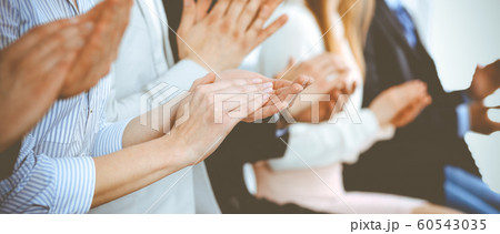 Business people clapping and applause at meeting or conference, close-up of hands. Group of unknown businessmen and women in modern white office. Success teamwork or corporate coaching concept 60543035