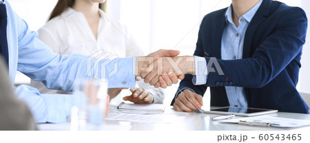 Business people shaking hands at meeting or negotiation, close-up. Group of unknown businessmen and women in modern office. Teamwork, partnership and handshake concept, toned picture Business people shaking hands at meeting or negotiation, close-up. Group of unknown businessmen and women in modern office. Teamwork, partnership and handshake concept, toned picture 60543465