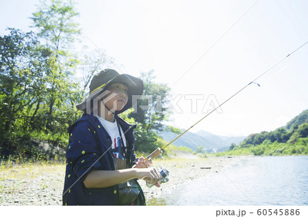 渓流釣りイメージ 釣りをする子供の写真素材