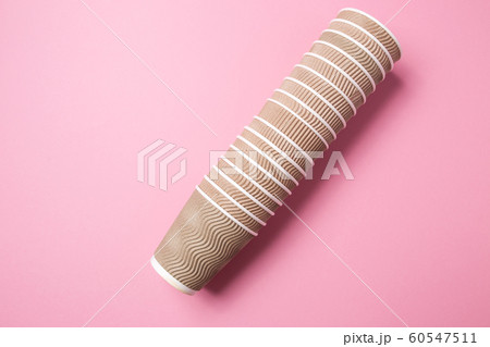 A stack of paper cups for hot drinks on a pink isolated background. 60547511