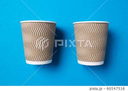 Paper cup for hot coffee or tea on a blue isolated background. Paper cup for hot coffee or tea on a blue isolated background. 60547516