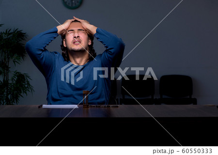 Young convict man sitting in dark room Young convict man sitting in dark room 60550333