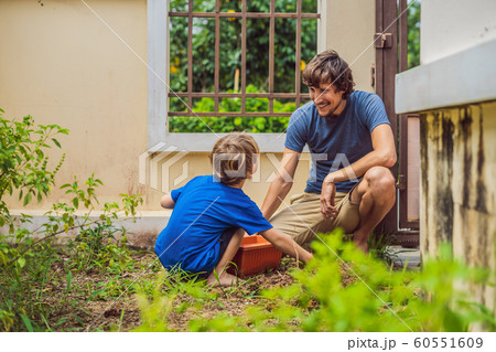 Father and son gardening in the garden near the house 60551609
