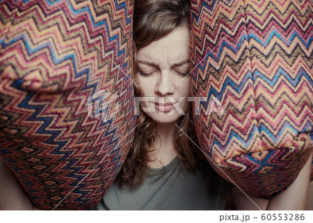 Woman close ears with the pillows. Stressed woman 60553286