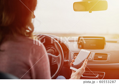 Woman using a smartphone while driving 60553287