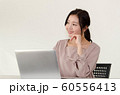 パソコンの前で微笑みながら楽しそうな考え事をしている女性 60556413