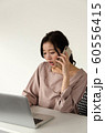 PCの前で不機嫌に電話する女性 60556415