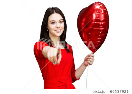 Girl in a red dress shows a finger at the camera. 60557921