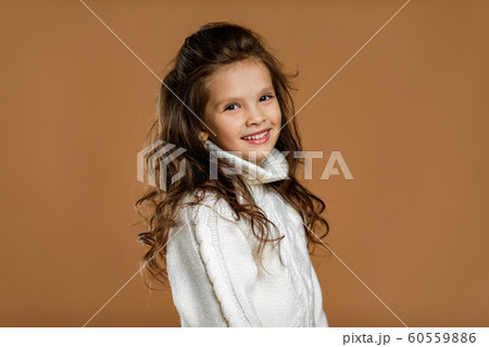 little girl in white sweater looking to camera 60559886