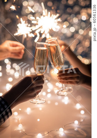 Hands of friends holding flutes of champagne and sparkling bengal lights 60561336