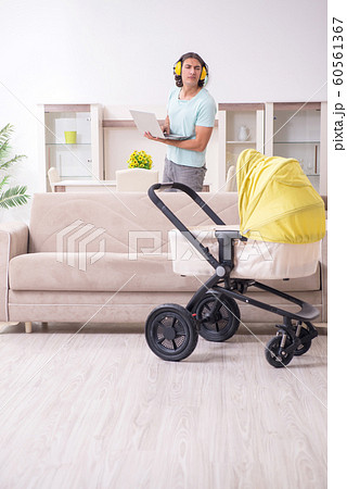 Young man looking after baby in pram 60561367