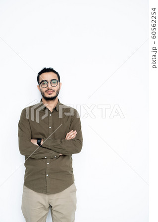 Young serious mixed-race businessman in casualwear looking at you in isolation Young serious mixed-race businessman in casualwear looking at you in isolation 60562254