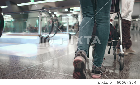woman with luggage cart walk at airport terminal 60564834
