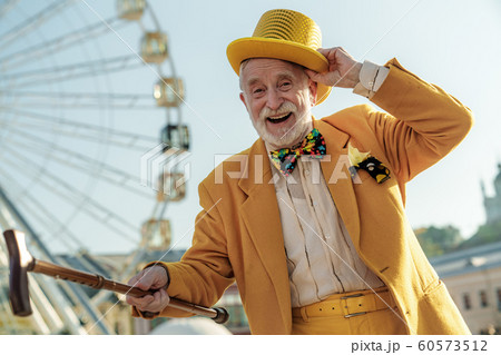 Happy aged man in coloured suit in amusement park 60573512