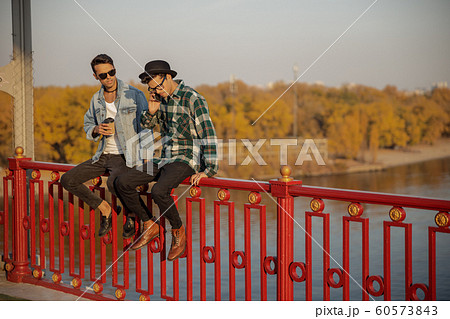 Young guy talking on the phone on the bridge Young guy talking on the phone on the bridge 60573843