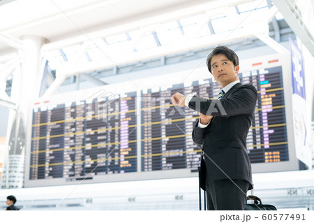 空港　ビジネスマン　時間　確認 60577491