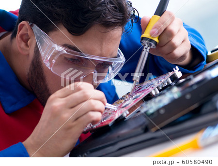 Repairman working in technical support fixing computer laptop tr 60580490