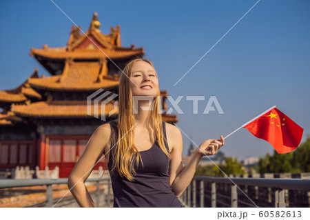 Enjoying vacation in China. Young woman with national chinese flag in Forbidden City. Travel to China concept. Visa free transit 72 hours, 144 hours in China 60582613