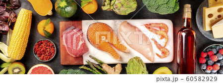 Food panorama, a flatlay with meat, fish, chicken and shrimps, vegetables and fruits, wine and cheese, shot from above on a dark background 60582929