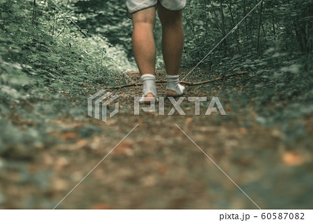 male feet walking with torn socks through a green 60587082