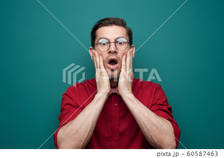 Close-up portrait of shocked young man in glasses 60587463