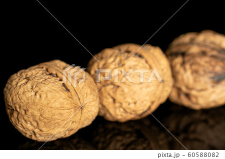 Fresh brown walnut isolated on black glass 60588082