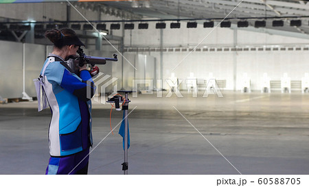 BULLET SHOOTING. girl in a blue suit is aiming at a target 60588705