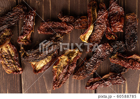 Sun dried tomato on brown wood Sun dried tomato on brown wood 60588785