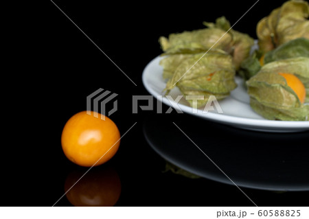 Fresh orange physalis isolated on black glass Fresh orange physalis isolated on black glass 60588825