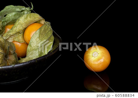 Fresh orange physalis isolated on black glass Fresh orange physalis isolated on black glass 60588834