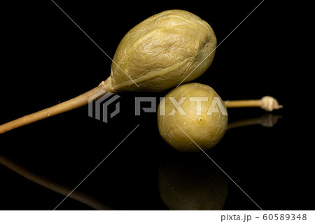 Green pickled caper isolated on black glass Green pickled caper isolated on black glass 60589348