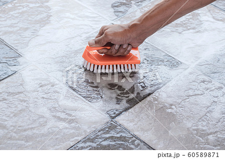Cleaning the tile floor. 60589871