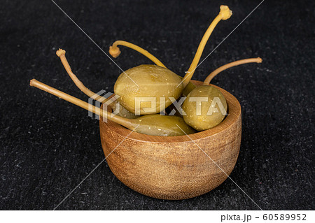 Green pickled caper on grey stone 60589952