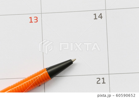 Orange pen is placed on the calendar in the 14th day and have copy space. Orange pen is placed on the calendar in the 14th day and have copy space. 60590652
