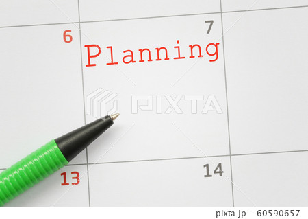 Green pen that points to a planning text. 60590657