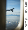 View from cabin of airplane.Through the window. Plane photography above clouds and mountains. 60591406